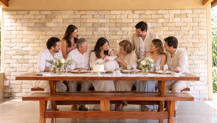 Almoço de batizado em família na mesa rústica de madeira do salão