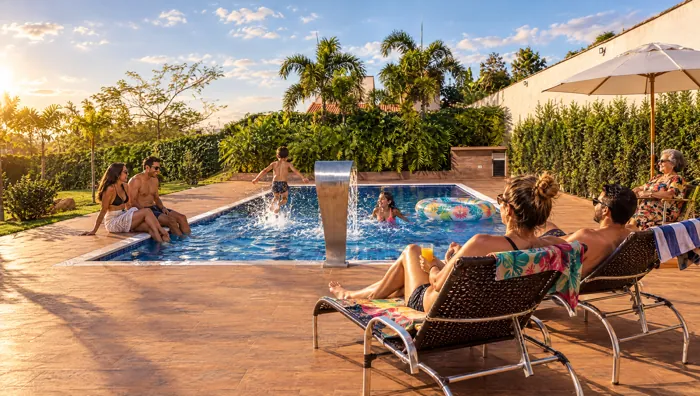 Família aproveitando a piscina em uma tarde de sol